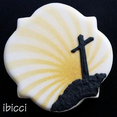 a cross on top of a shell with the word jesus written in black and white