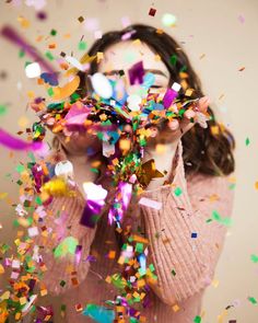 a woman covering her eyes with confetti and streamers in front of her