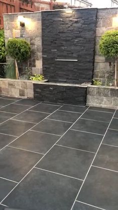 an outdoor patio with black slate tiles and potted plants