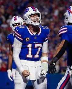 bills football players standing on the sidelines with helmets on and one holding his mouth open