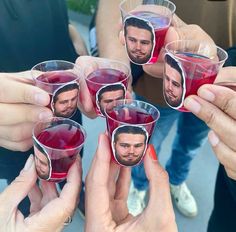 several people holding up wine glasses with pictures on them