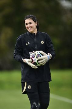 a woman holding a soccer ball in her hands