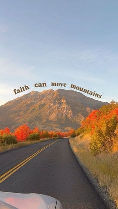 a car is driving down the road with mountains in the background and words above it that read, faith can move mountains