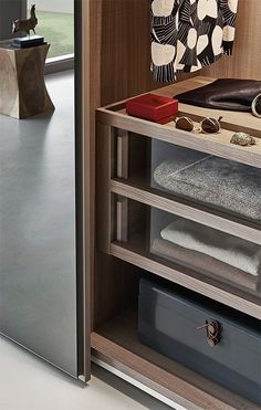 an open cabinet with folded towels and other items