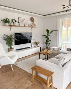 a living room filled with furniture and a flat screen tv mounted on a wall next to a window