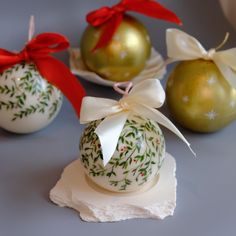 three christmas ornaments with bows on them