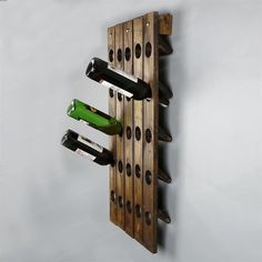 a wine rack made out of wooden planks with bottles hanging from the top and bottom