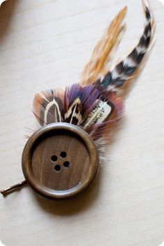 a wooden button with feathers attached to it