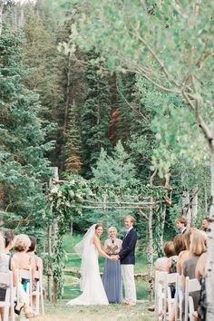 a bride and groom standing at the end of their wedding ceremony with trees in the background