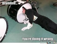 a man laying on the ground with his head in a drum kit and caption that reads, you're doing it wrong