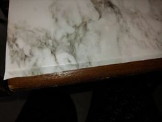 a white marble counter top sitting on top of a wooden table