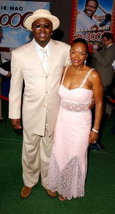 a man and woman standing next to each other on a green carpet