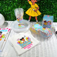 a table with various items on it including t - shirts, napkins and balloons