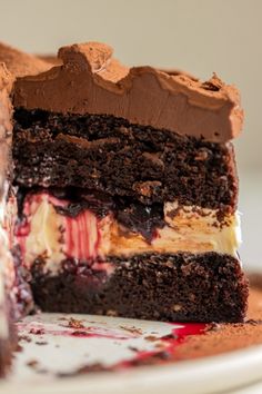 a piece of chocolate cake on a plate with the rest of it cut in half