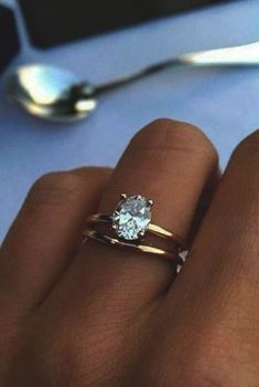 a close up of a person's hand with a ring on it