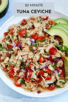 a white bowl filled with rice, tomatoes and avocado on top of a table