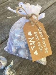 a bag filled with herspoo kisses sitting on top of a wooden table next to two chocolate candies