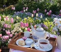 a tray filled with tea and flowers on top of a table