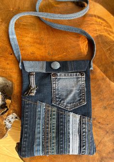 a denim bag with an old pair of jeans in the pocket on a wooden table