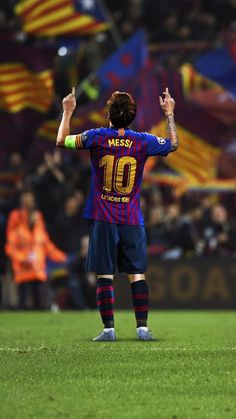 a soccer player with his arms in the air and hands raised up as he stands on a field