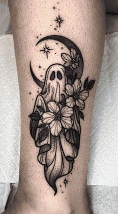 a woman's leg with flowers and a skull tattoo on it, in the shape of a half moon