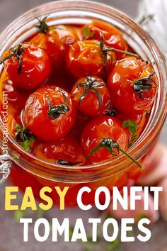 a glass jar filled with tomatoes on top of a table