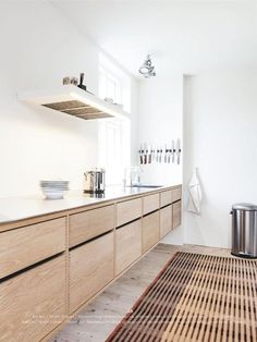 a kitchen with wooden cabinets and white walls