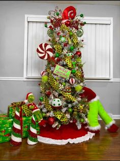 a christmas tree decorated with candy canes and candies is sitting on the floor