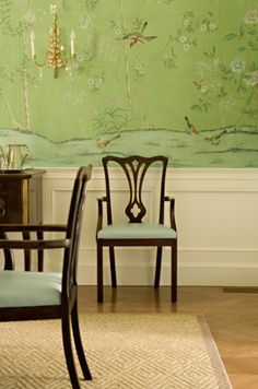 a dining room with green wallpaper and chairs