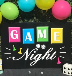 a game night sign surrounded by balloons and dices