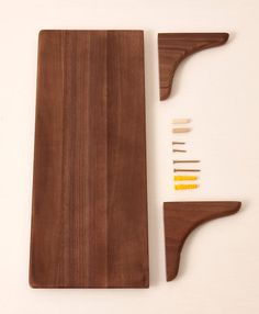 a wooden cutting board and knife rest on a white surface next to other woodworking tools