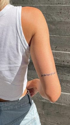 a woman with a small tattoo on her arm that reads, you are the angel of the north