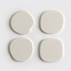 four pieces of white foam sitting on top of each other in front of a white background