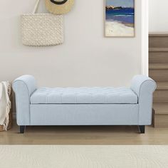 a blue bench sitting in front of a wall with pictures on it and a hat hanging above