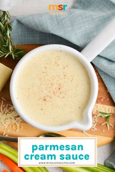 a bowl of parmesan cream sauce next to sliced celery and carrots