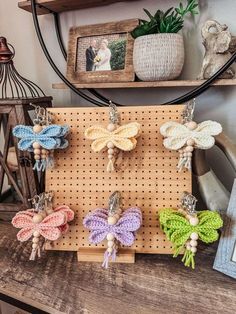 several crocheted butterflies are hanging on a peg board