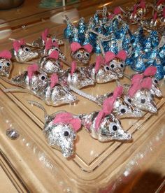 there are many silver and pink mice on the trays that have candy in them