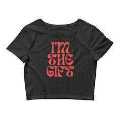 "Elevate your style game with this must-have \"I'm The Gift\" Crop Top! Made from a premium blend of 52% combed ring-spun cotton and 48% polyester, this top is designed to provide a comfortable and stylish fit. The 40 singles fabric weight of 3.6 oz/yd² (122 g/m²) and slim fit design with side-seam construction make this top a versatile addition to your wardrobe. Available in black or white, this crop top is sourced from Nicaragua, the US, or Honduras and is made to order, helping reduce overpro Black Letter Print Top As A Gift, Black Tops With Letter Print For Gift, Black Letter Print Top As Gift, Trendy Black T-shirt For Gift, Black Fitted Top As A Gift, Black Fitted Top For Gift, Cotton Tops With Graphic Design, Fitted Black T-shirt As Gift, Cotton Graphic Design Top As Gift