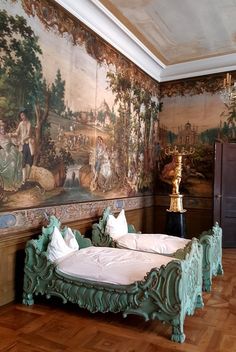 a bedroom with a large painting on the wall next to a bed in front of a dresser