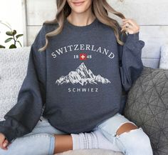 PORTION OF ALL PROCEEDS ARE DONATED TO CHARITY! GRAB ONE TODAY! Embrace the allure of the Swiss Alps with our Switzerland Sweatshirt, a cozy and stylish piece perfect for any adventure. This Swiss Mountains Crewneck Pullover showcases a stunning design inspired by the majestic peaks of Switzerland, making it an ideal choice for mountain lovers and travelers alike. Whether you're planning a trip to Switzerland or reminiscing about your Suisse Vacation, this sweater offers both comfort and a conne Travel To Switzerland, Swiss Mountains, Tennessee Travel, National Park Shirt, Switzerland Travel, Swiss Alps, Travel Souvenirs, Camping Gifts, Gatlinburg