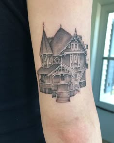 a woman's arm with a tattoo of a house and stairs on the side