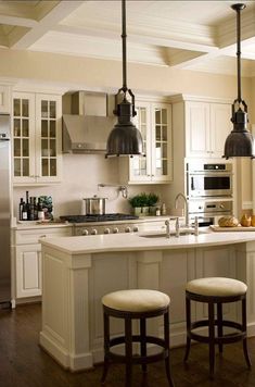 a kitchen with two stools next to an island