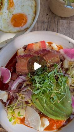 a white plate topped with meat and veggies on top of a wooden table