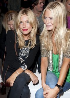 two women sitting next to each other at a fashion show