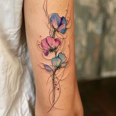 a woman's leg with flowers on it and an artistic tattoo design in the middle