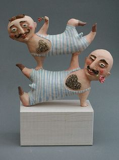 two figurines that are sitting on top of each other in the same position