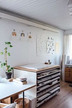 a room with lots of drawers in it and a plant on top of the desk