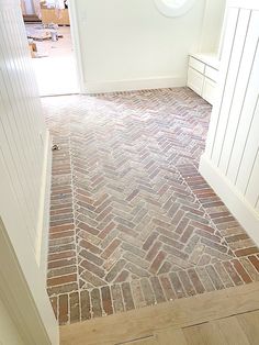 an empty room with brick flooring and white walls