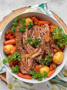 a bowl filled with meat, potatoes and carrots