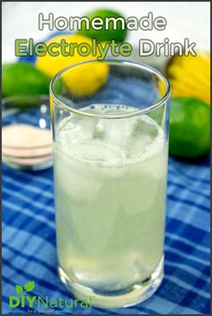 a glass filled with ice sitting on top of a table next to lemons and limes